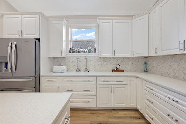 kitchen featuring decorative backsplash, light wood-type flooring, white cabinetry, and stainless steel refrigerator with ice dispenser