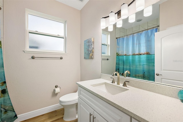 bathroom with hardwood / wood-style floors, vanity, toilet, and plenty of natural light