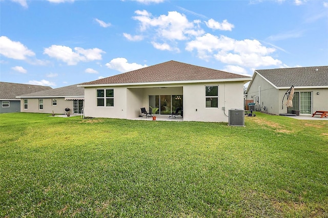 rear view of property with a lawn, a patio area, and central air condition unit