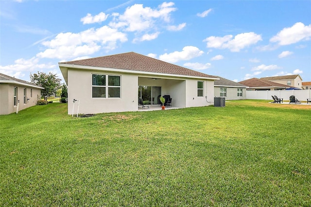 back of house with ceiling fan, a patio area, a yard, and central AC