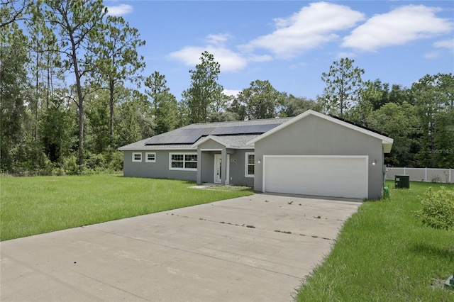 ranch-style home with solar panels, a garage, and a front lawn