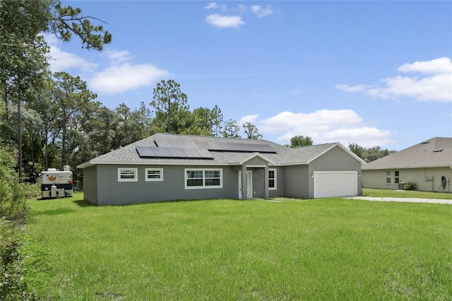 ranch-style house featuring solar panels, a garage, and a front yard