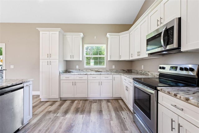 kitchen featuring white cabinetry, stainless steel appliances, light hardwood / wood-style flooring, and light stone counters