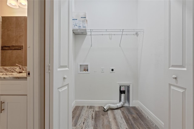 laundry area featuring sink, hookup for an electric dryer, light hardwood / wood-style flooring, and hookup for a washing machine