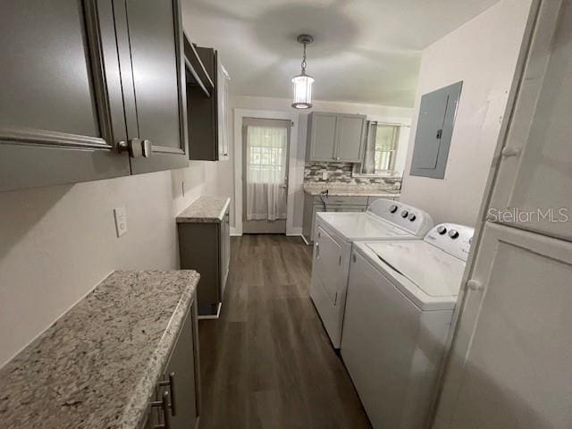 laundry room with dark wood-type flooring, separate washer and dryer, electric panel, and cabinets