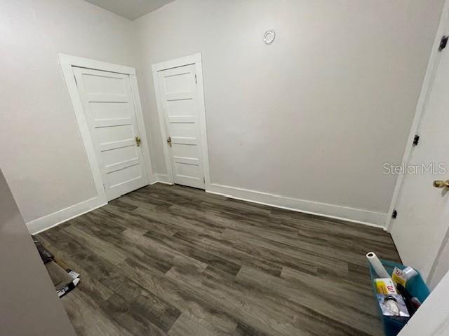 unfurnished room with dark hardwood / wood-style floors