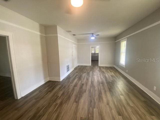 unfurnished living room featuring ceiling fan and dark hardwood / wood-style floors