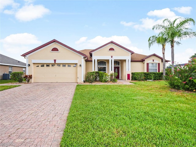 view of front of house with a garage, a front lawn, and cooling unit