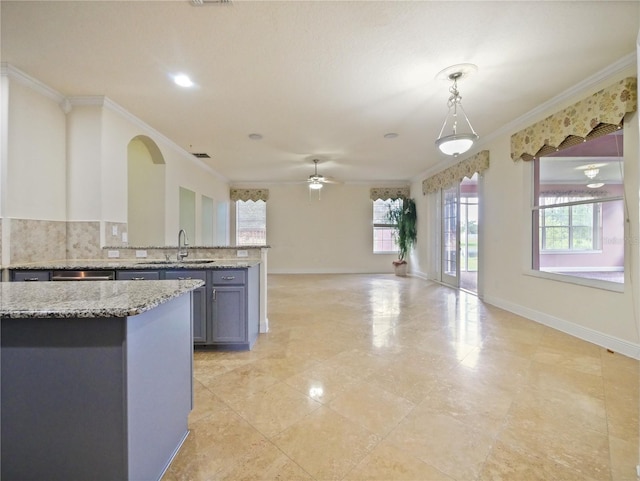 kitchen featuring pendant lighting, ceiling fan, sink, and crown molding