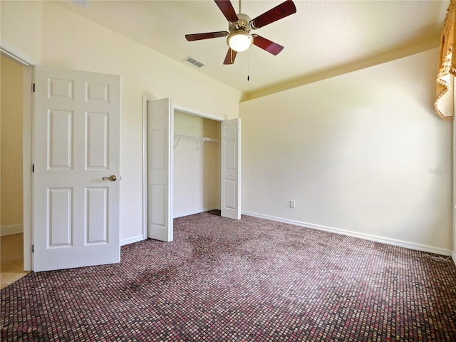 unfurnished bedroom with ceiling fan, a closet, vaulted ceiling, and dark colored carpet