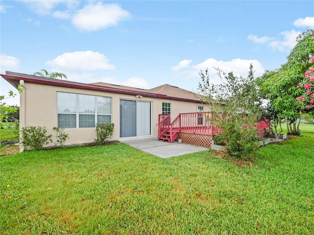 rear view of property with a lawn, a patio, and a deck