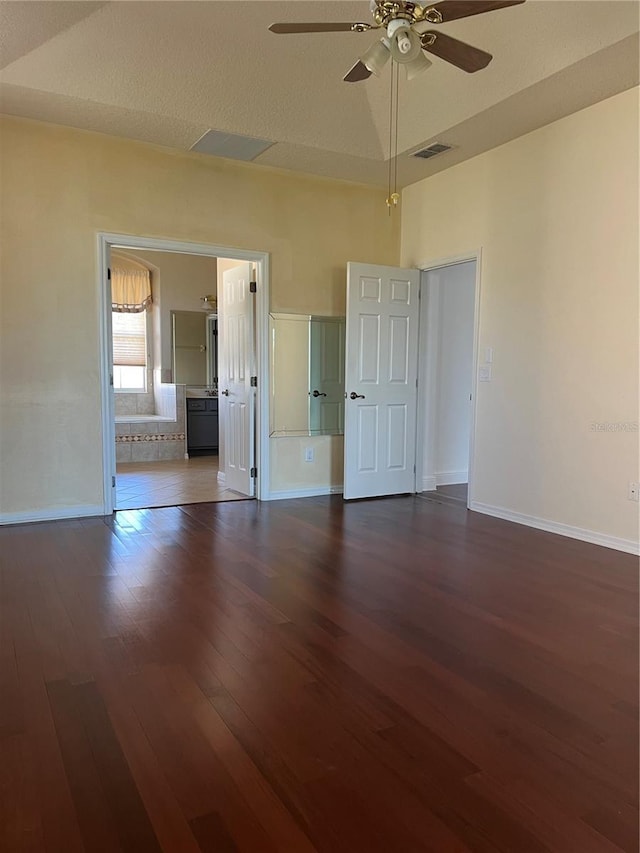 empty room with ceiling fan, dark hardwood / wood-style flooring, and vaulted ceiling