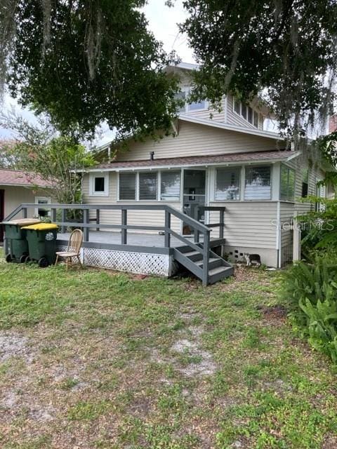 rear view of property with a lawn and a deck