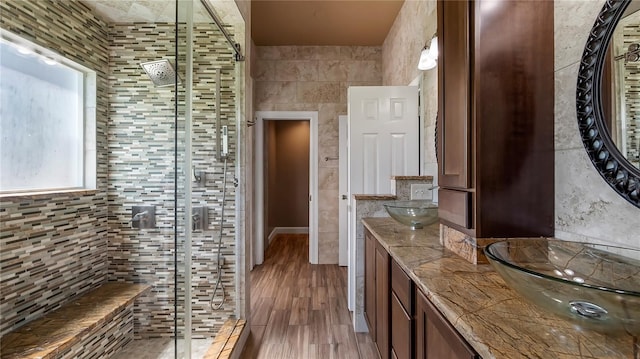 bathroom with hardwood / wood-style flooring, vanity, and a shower with shower door