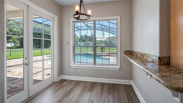 doorway with french doors, light hardwood / wood-style flooring, and an inviting chandelier