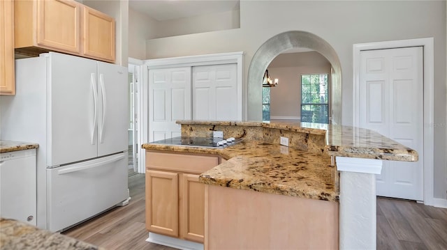 kitchen with light brown cabinets, white fridge, light hardwood / wood-style flooring, and electric cooktop