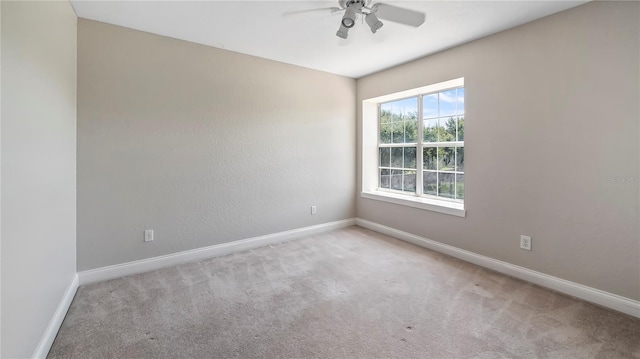 carpeted spare room featuring ceiling fan