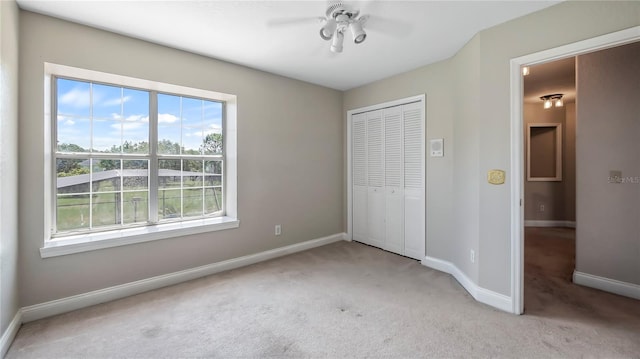 unfurnished bedroom featuring light carpet, a closet, and ceiling fan