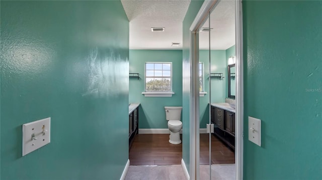 bathroom with vanity, a textured ceiling, and toilet