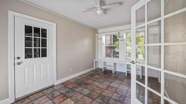 unfurnished sunroom featuring ceiling fan