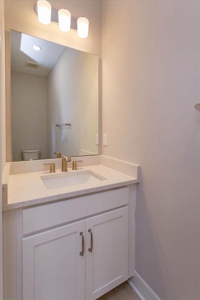 bathroom featuring vanity and toilet