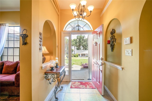 tiled entrance foyer with an inviting chandelier