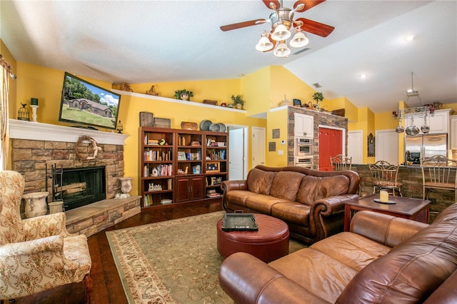 living room with ceiling fan, a fireplace, wood-type flooring, and vaulted ceiling