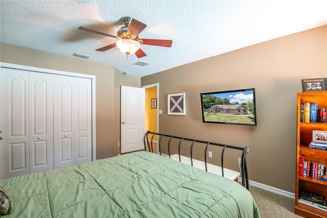 bedroom featuring carpet, ceiling fan, a textured ceiling, and a closet