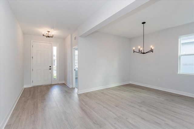 foyer entrance with a notable chandelier and light wood-type flooring