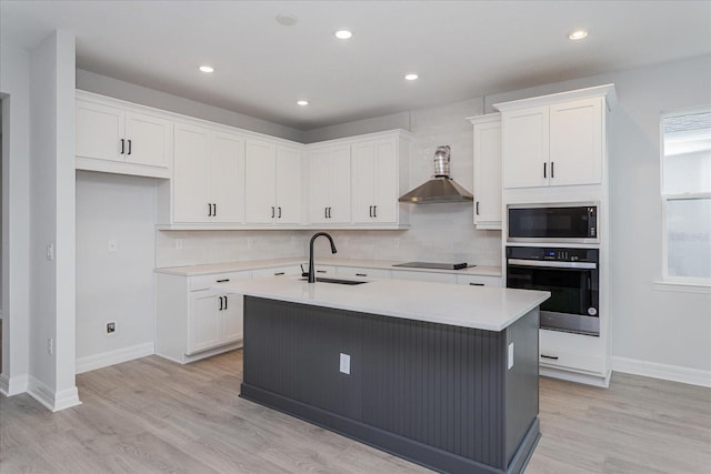 kitchen featuring appliances with stainless steel finishes, sink, white cabinetry, and an island with sink