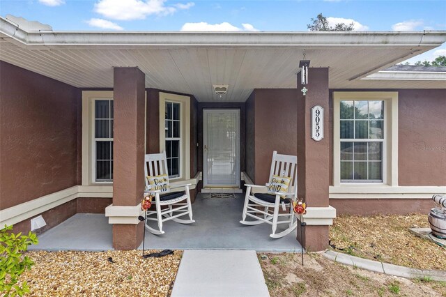 view of exterior entry with a porch