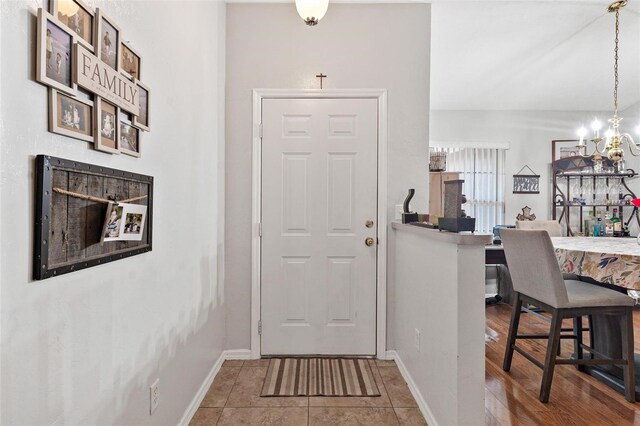 tiled foyer entrance featuring a chandelier