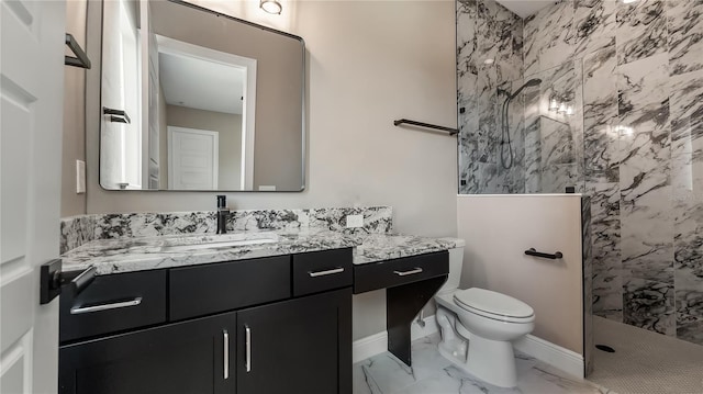 bathroom with vanity, toilet, and tiled shower