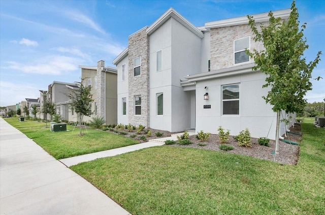 view of front of house with central air condition unit and a front yard