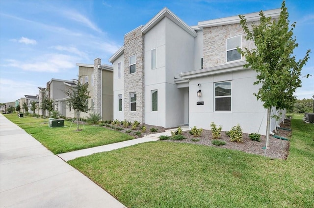 view of front of property featuring stone siding, stucco siding, and a front lawn