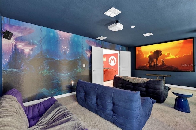 cinema room with carpet flooring, visible vents, baseboards, and a textured ceiling