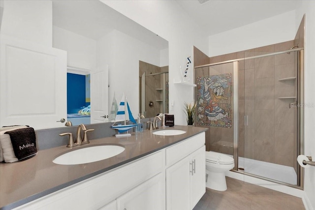 bathroom with double vanity, a shower stall, toilet, and a sink