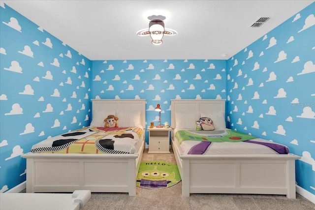 carpeted bedroom featuring visible vents, wallpapered walls, and baseboards