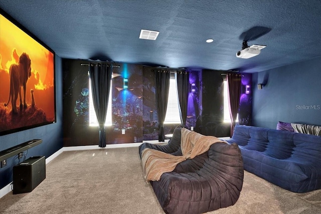 carpeted home theater room featuring visible vents, baseboards, and a textured ceiling