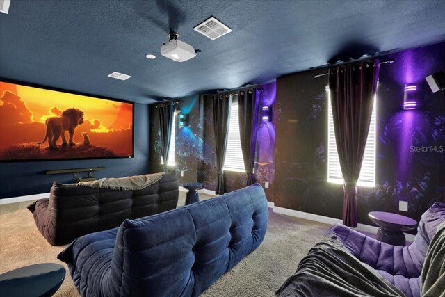 home theater featuring visible vents, carpet floors, and a textured ceiling