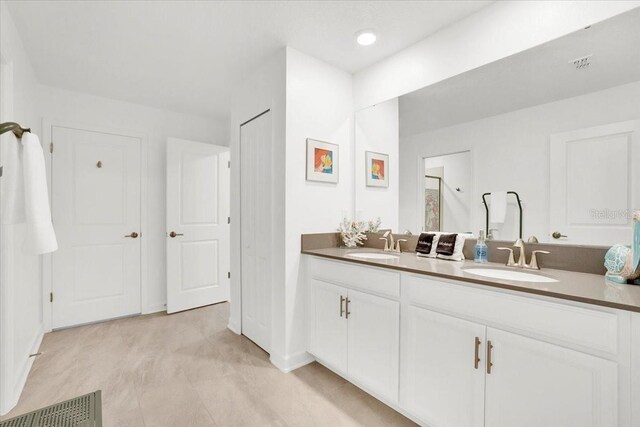 bathroom featuring tile patterned floors and double vanity