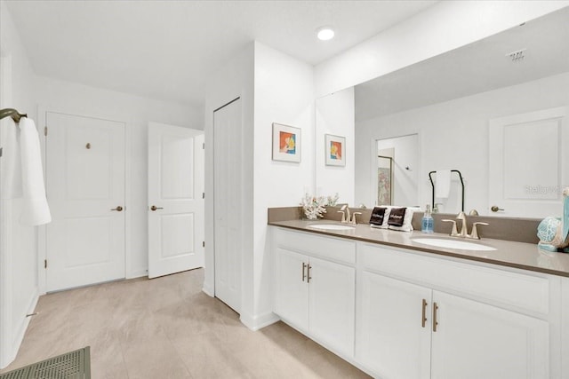 full bath with double vanity, a shower, visible vents, and a sink