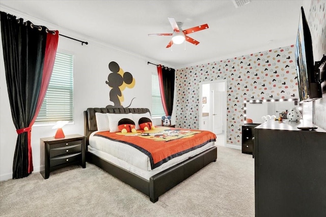 bedroom featuring a ceiling fan, baseboards, ensuite bath, ornamental molding, and light carpet