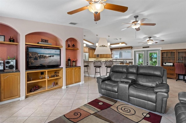 living room with french doors, built in shelves, ceiling fan, and light tile floors