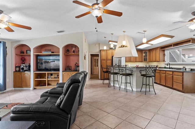 living room featuring light tile floors, sink, ceiling fan, and built in shelves