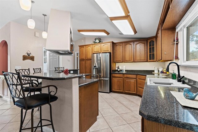 kitchen featuring sink, vaulted ceiling, stainless steel fridge with ice dispenser, and light tile floors