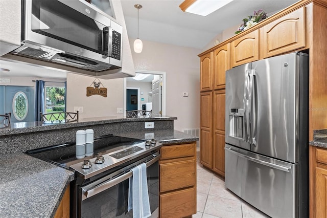 kitchen featuring lofted ceiling, stainless steel appliances, dark stone counters, pendant lighting, and light tile floors