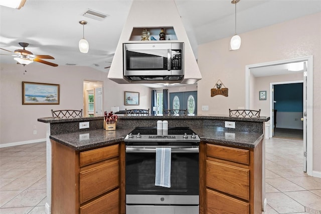 kitchen with decorative light fixtures, light tile flooring, and stainless steel appliances