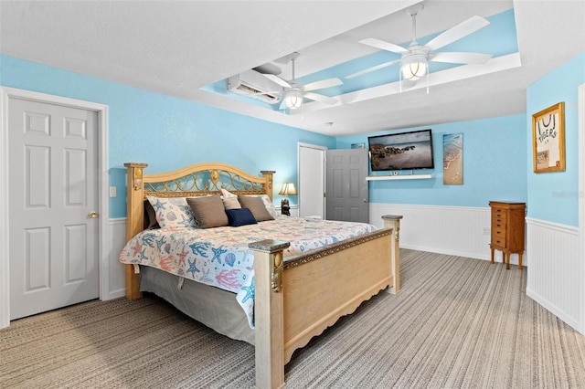 bedroom featuring a raised ceiling, ceiling fan, and carpet floors