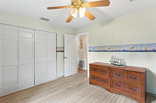 bedroom with ceiling fan, a closet, and light colored carpet